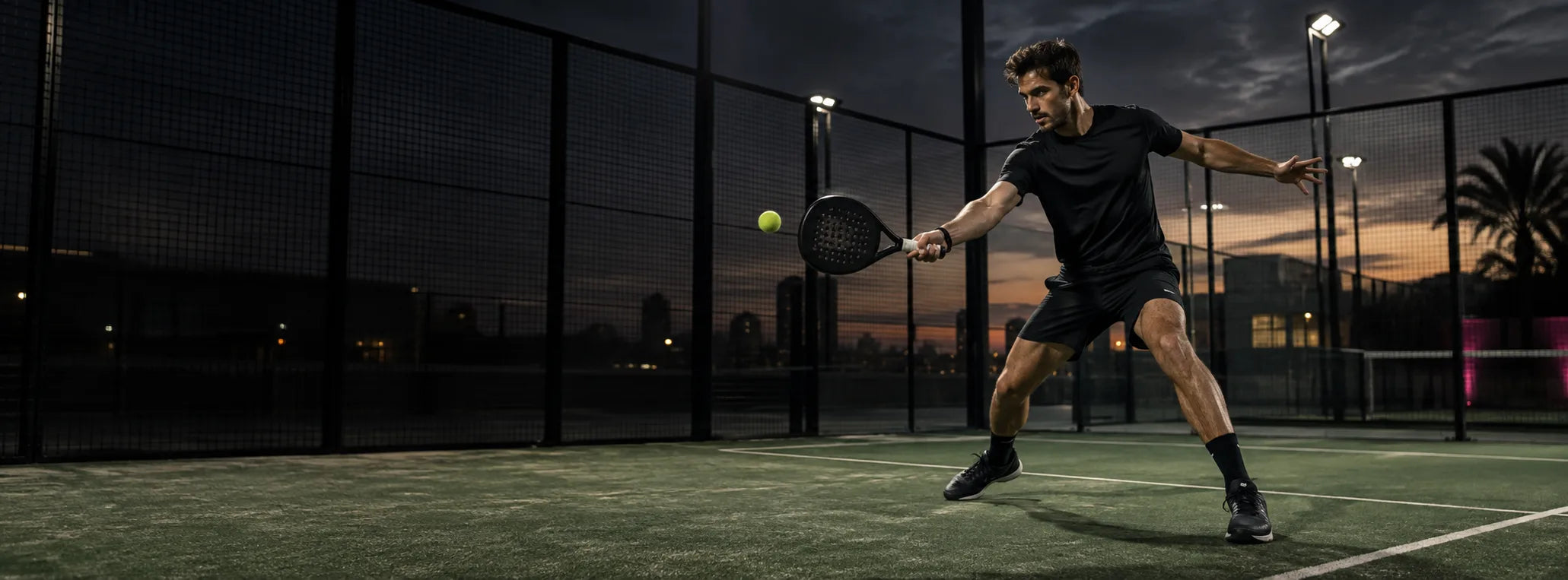 Padel player serving under court lights